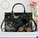 Studio display of nocturnal black cat and crescent moon floral artwork.