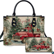 Front view of holiday handbag featuring vintage red truck with gifts in snowy forest