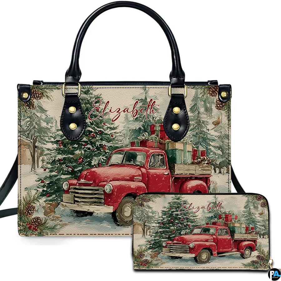 Front view of holiday handbag featuring vintage red truck with gifts in snowy forest