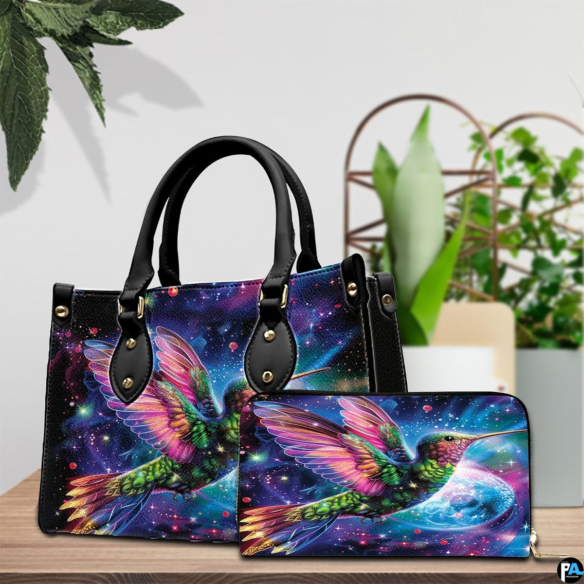 Model holding cosmic galaxy handbag outdoors showcasing radiant flying hummingbird artwork.