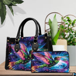 Model holding cosmic galaxy handbag outdoors showcasing radiant flying hummingbird artwork.