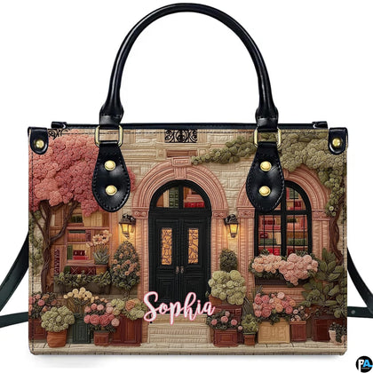 Front product view of quilted bookshop handbag displaying library facade artwork on white background.