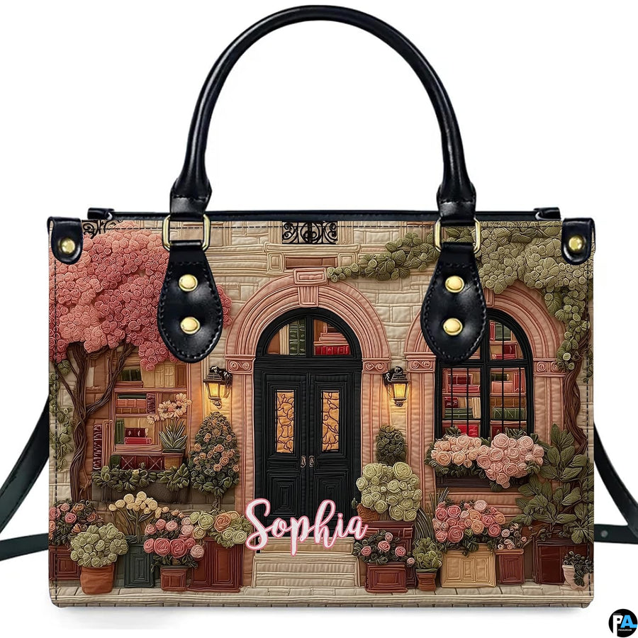 Front product view of quilted bookshop handbag displaying library facade artwork on white background.
