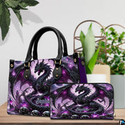 Gothic dragon handbag and wallet set shown together on wooden tabletop next to houseplant.