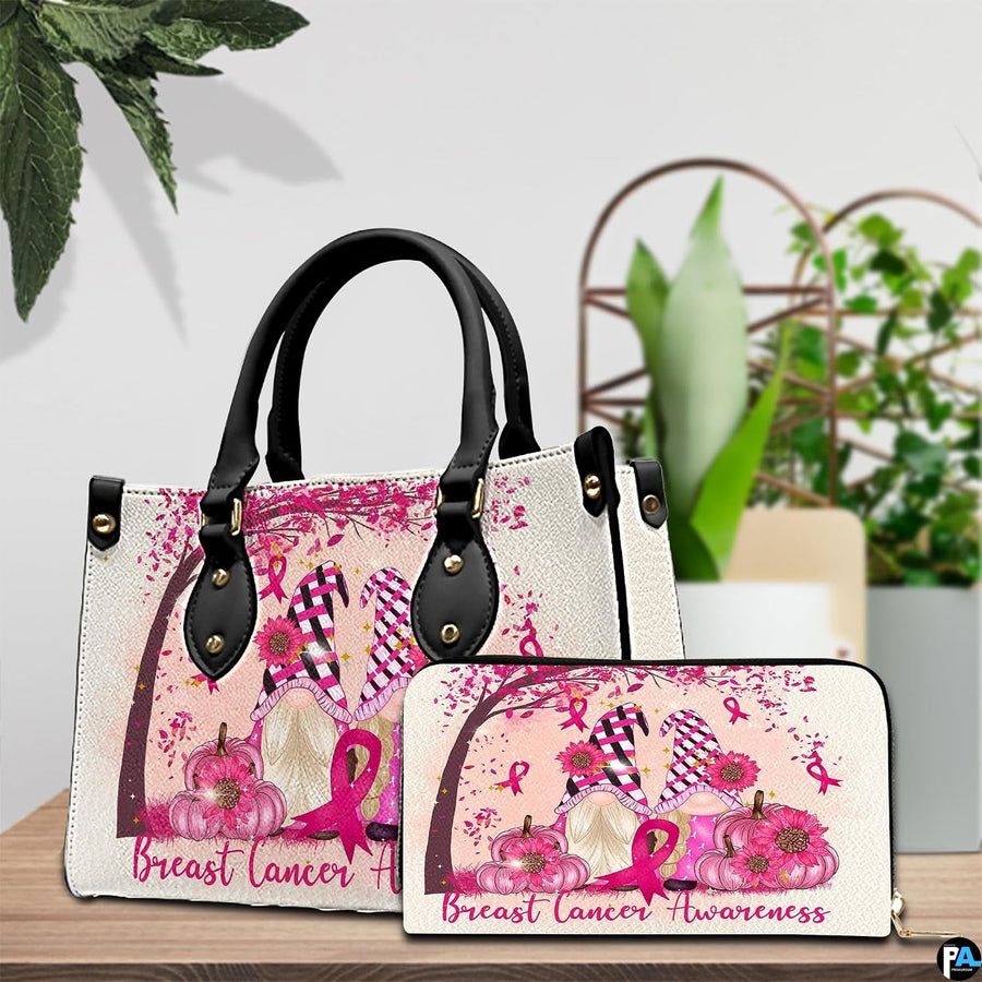 Pink ribbon art accessory and companion item arranged together on timber tabletop near green potted foliage.