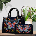 Top-handle handbag and matching wallet displayed together beside potted houseplants.