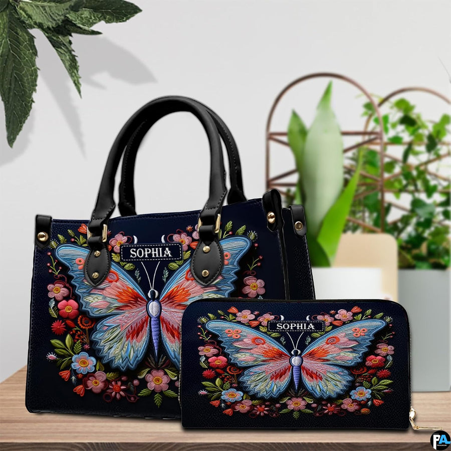 Top-handle handbag and matching wallet displayed together beside potted houseplants.