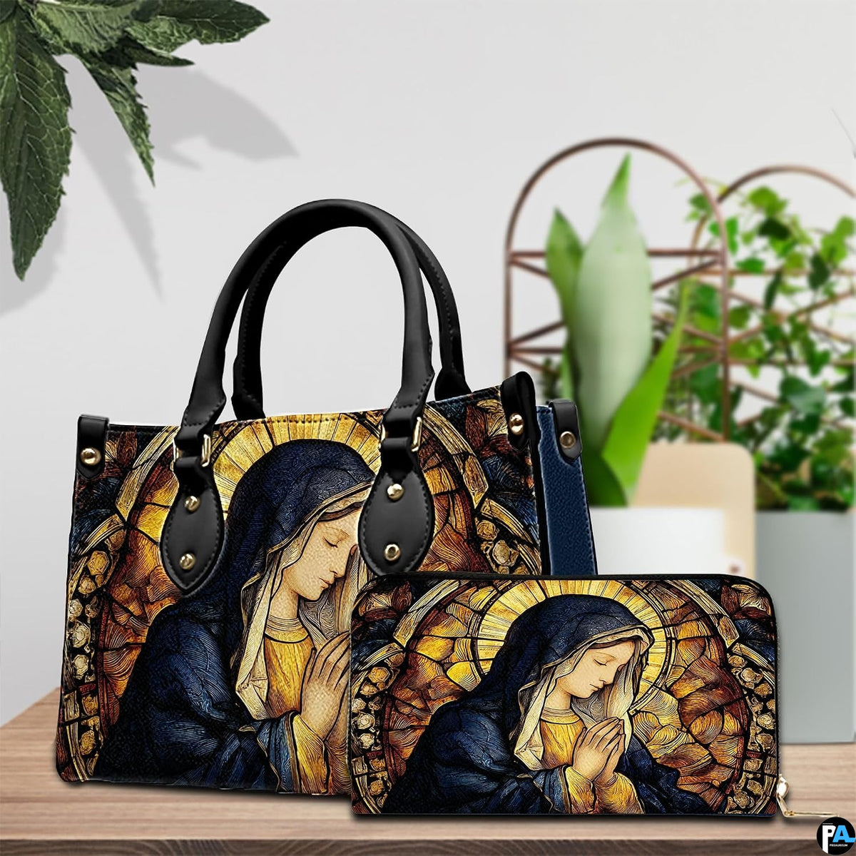 Stained glass Mary handbag and matching wallet displayed together with potted greenery