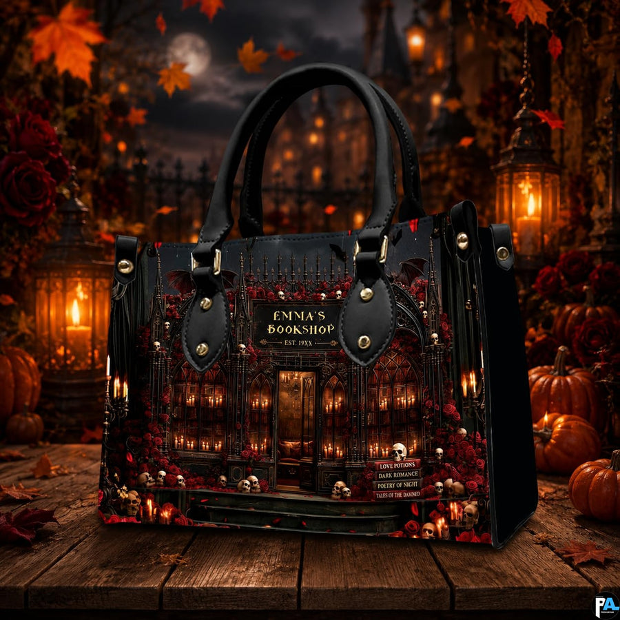 Tabletop view of gothic bookstore artwork surrounded by pumpkin lanterns and fallen autumn foliage.