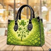 Angled clover tree handbag with dense green ground cover and gold sparkles