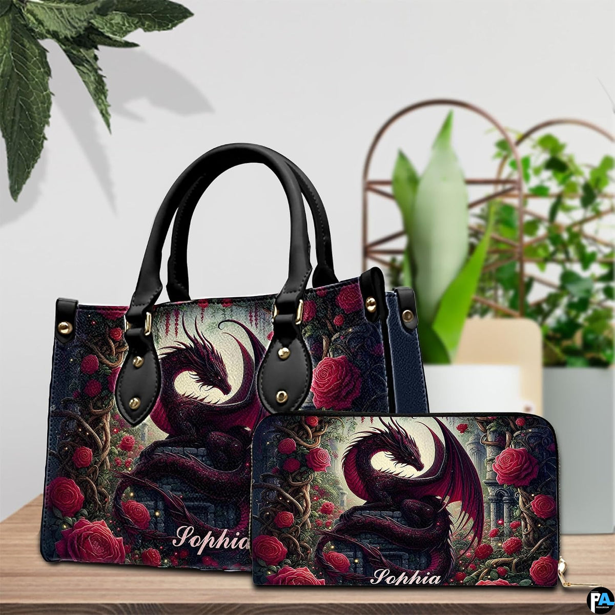 Gothic dragon handbag and wallet set displayed on wooden table beside houseplant.