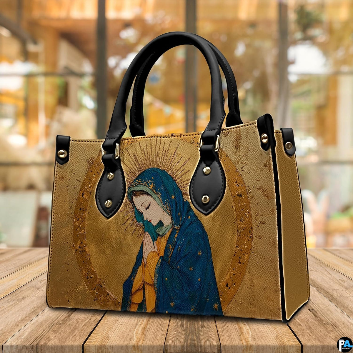 Renaissance Virgin Mary handbag displayed in three-quarter view on wooden cafe table.