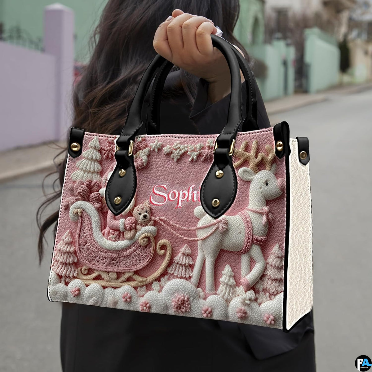 Model carrying the pink Santa and reindeer handbag outdoors by the top handles.