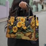Perspective view of yellow daisy bouquet handbag and wallet pair