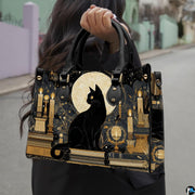 Black cat and candle artwork held outdoors along an urban sidewalk.