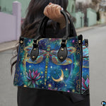 Front view of celestial dragonfly handbag with golden crescent moon and blooming magenta lotus flower