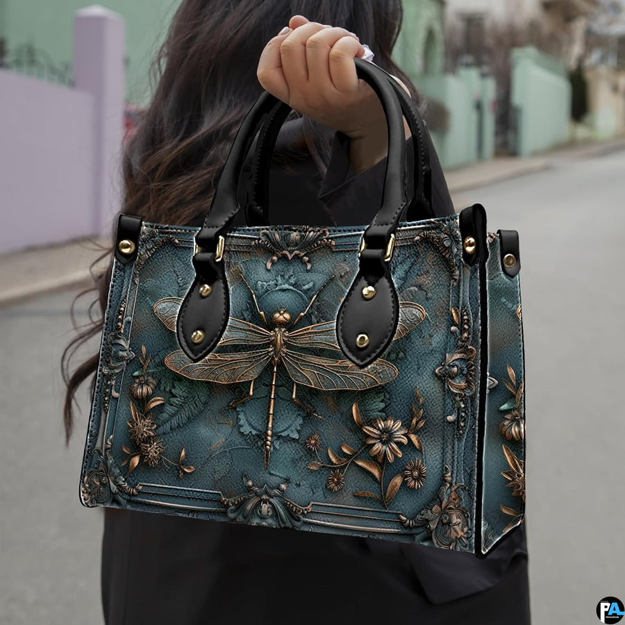 Front view of baroque teal handbag with sculpted bronze dragonfly and ornate rococo corner scrollwork