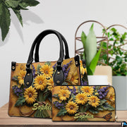 Close-up front view of handbag showing yellow daisies and lavender