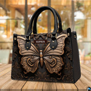 Swallowtail butterfly handbag resting on a sunny outdoor wooden deck with cafe windows in view.