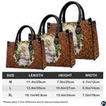 Tabletop display of tooled Madonna handbag highlighting carved acanthus relief and meadow portrait