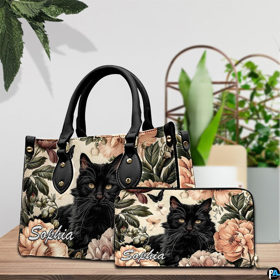 Tabletop presentation highlighting fluffy black cat art resting beside leafy indoor greenery.