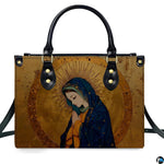 Direct front studio shot of gilded Renaissance Virgin Mary handbag on white backdrop.