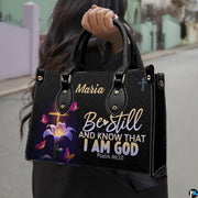 Outdoor lifestyle photo of glowing cross handbag carried by top handle on a city street.
