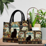 Library cat stained glass art resting beside lush potted greenery on a wooden surface.