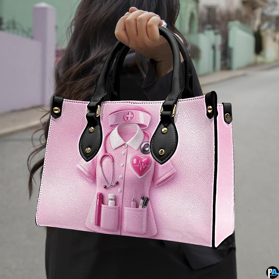 Perspective angle of pink nurse handbag showcasing front clinical uniform graphic and top handles