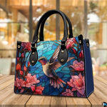Lifestyle display presenting the stained glass hummingbird handbag carried over the shoulder.