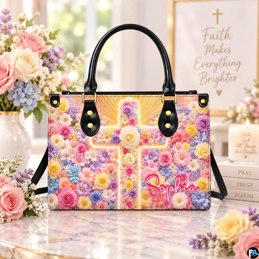 Floral cross handbag displayed on marble tabletop with rose vase and devotional candle.