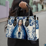 Street style lifestyle photo of model wearing blue ceramic tile Virgin Mary handbag.