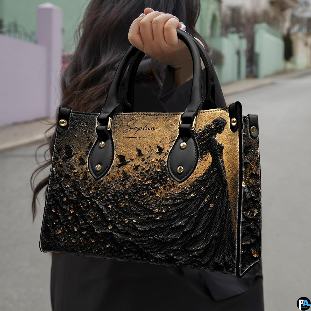 Gothic witch handbag and wallet displayed on wooden table beside potted plant.