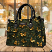 Golden butterfly embossed handbag standing on a wooden table in a cafe.