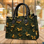 Golden butterfly embossed handbag standing on a wooden table in a cafe.