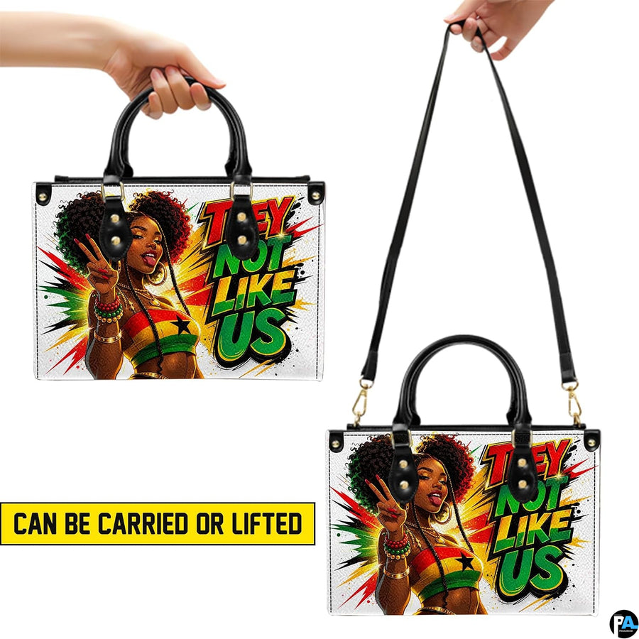 Afrocentric portrait handbag shown with top handles and long strap