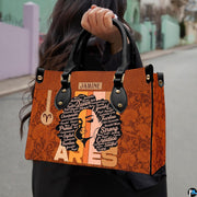 Front view of zodiac afro handbag showing typography word art portrait and cognac damask.
