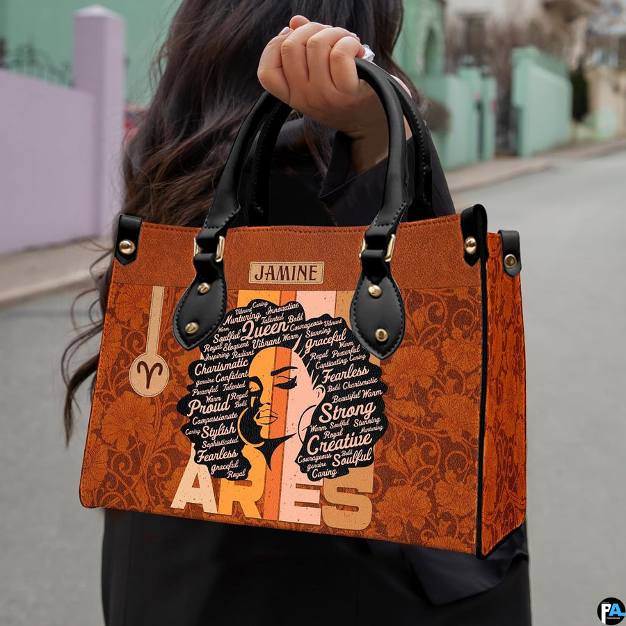 Front view of zodiac afro handbag showing typography word art portrait and cognac damask.