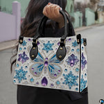 Side profile of crystal butterfly handbag showing structured silhouette and black carrying handles.