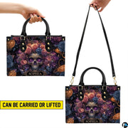 Cosmic skull floral handbag carrying demonstration showing top handle and shoulder strap carry.