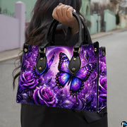 Outdoor lifestyle view of purple butterfly handbag carried by model