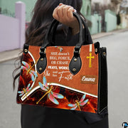 Angled view showing structured dragonfly and cross handbag