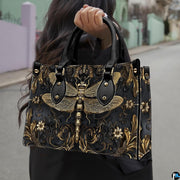 Street lifestyle view of model carrying gothic gold dragonfly handbag by the top handle