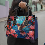 Angled view displaying the vibrant stained glass hummingbird and floral artwork across the front.