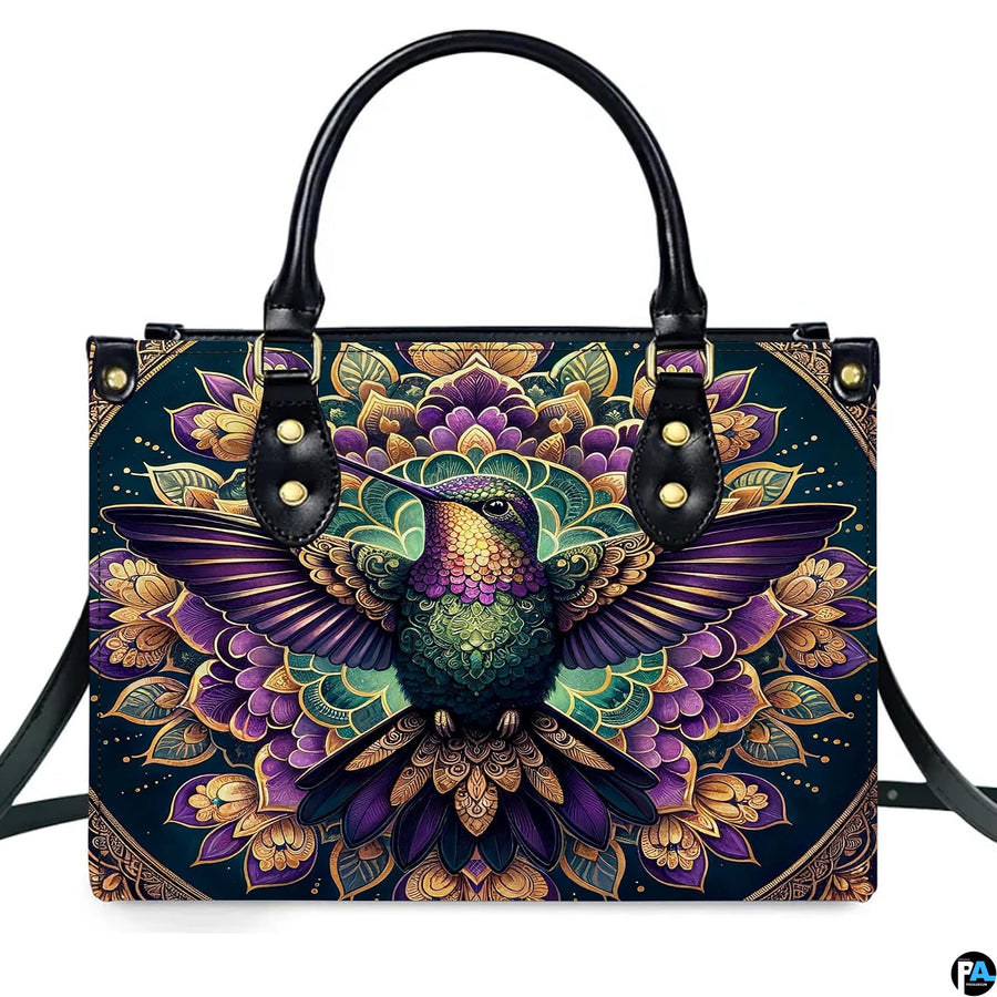 Studio front shot of handbag against white background highlighting purple hummingbird and lotus mandala.