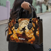 Stained glass Halloween witch handbag held by top handle while walking outdoors along a street.