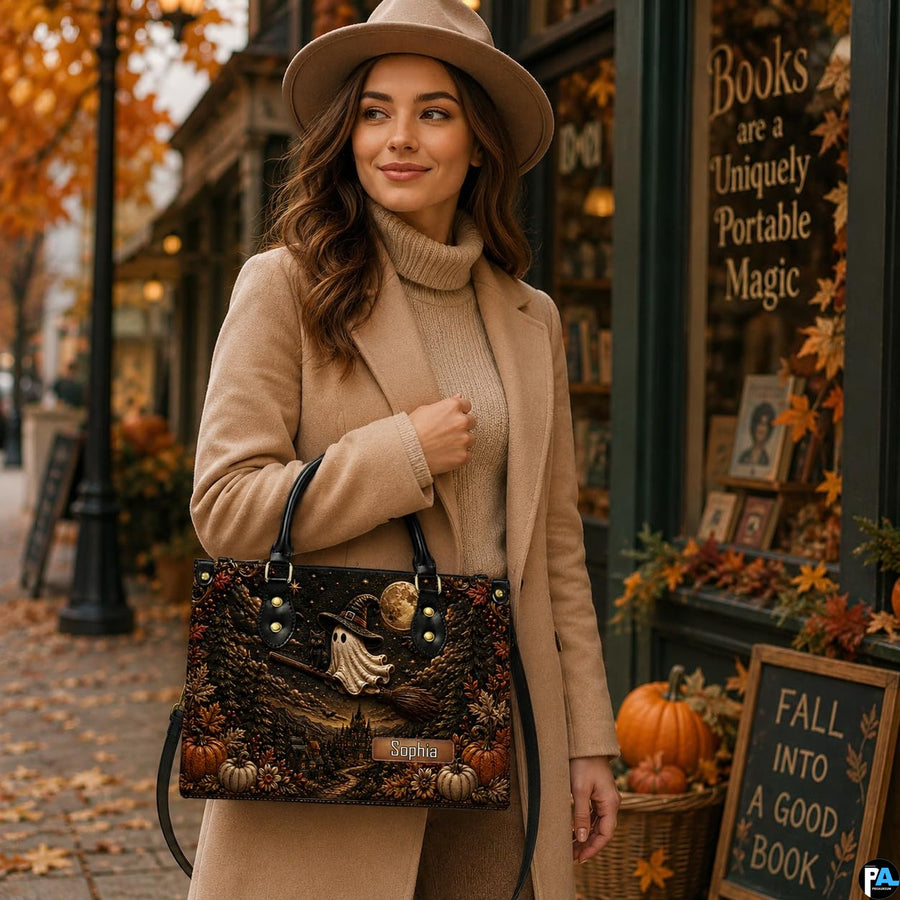 Outdoor lifestyle perspective showing structured satchel held beside autumn storefront decor.
