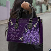 Angled view showing structured purple hummingbird and lavender handbag