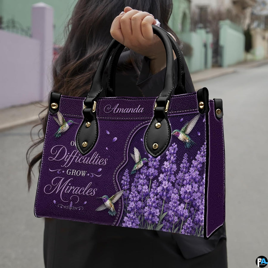 Angled view showing structured purple hummingbird and lavender handbag