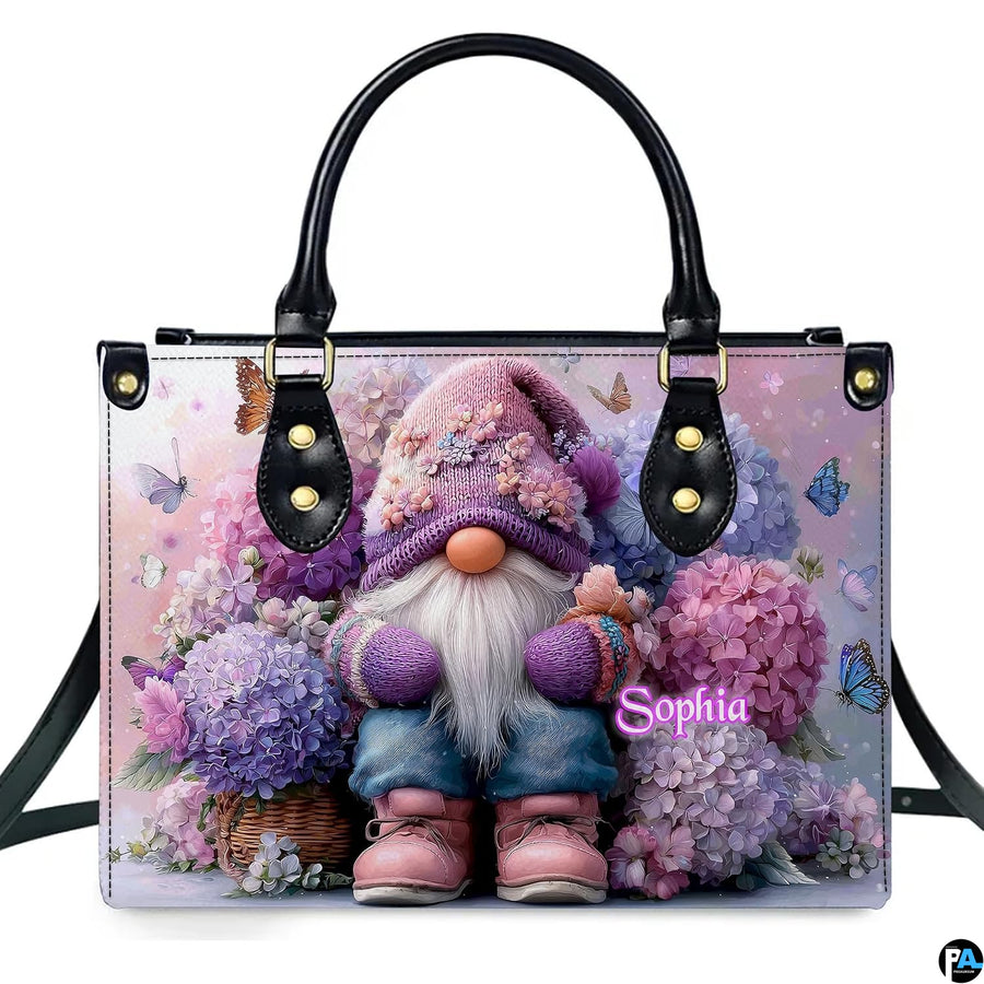 Front view of garden gnome and hydrangea handbag on white backdrop.